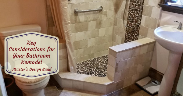 Beautiful bathroom remodel with tan tile and dark pebble features.